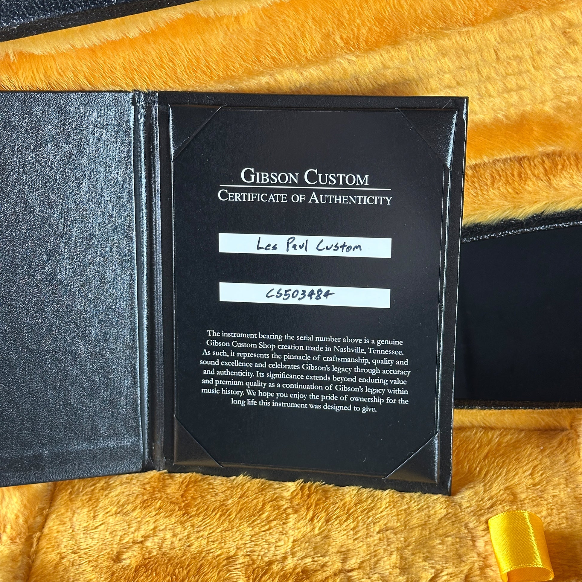 Gibson Custom Certificate of Authenticity on a yellow textured surface