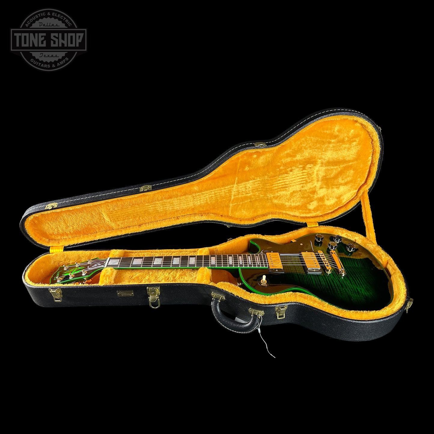 Guitar in an open case with a visible 'Tone Shop' logo.