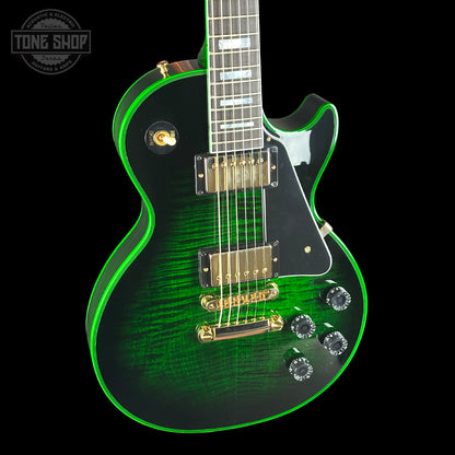 Green electric guitar with gold hardware on a black background, featuring 'Tone Shop' logo.