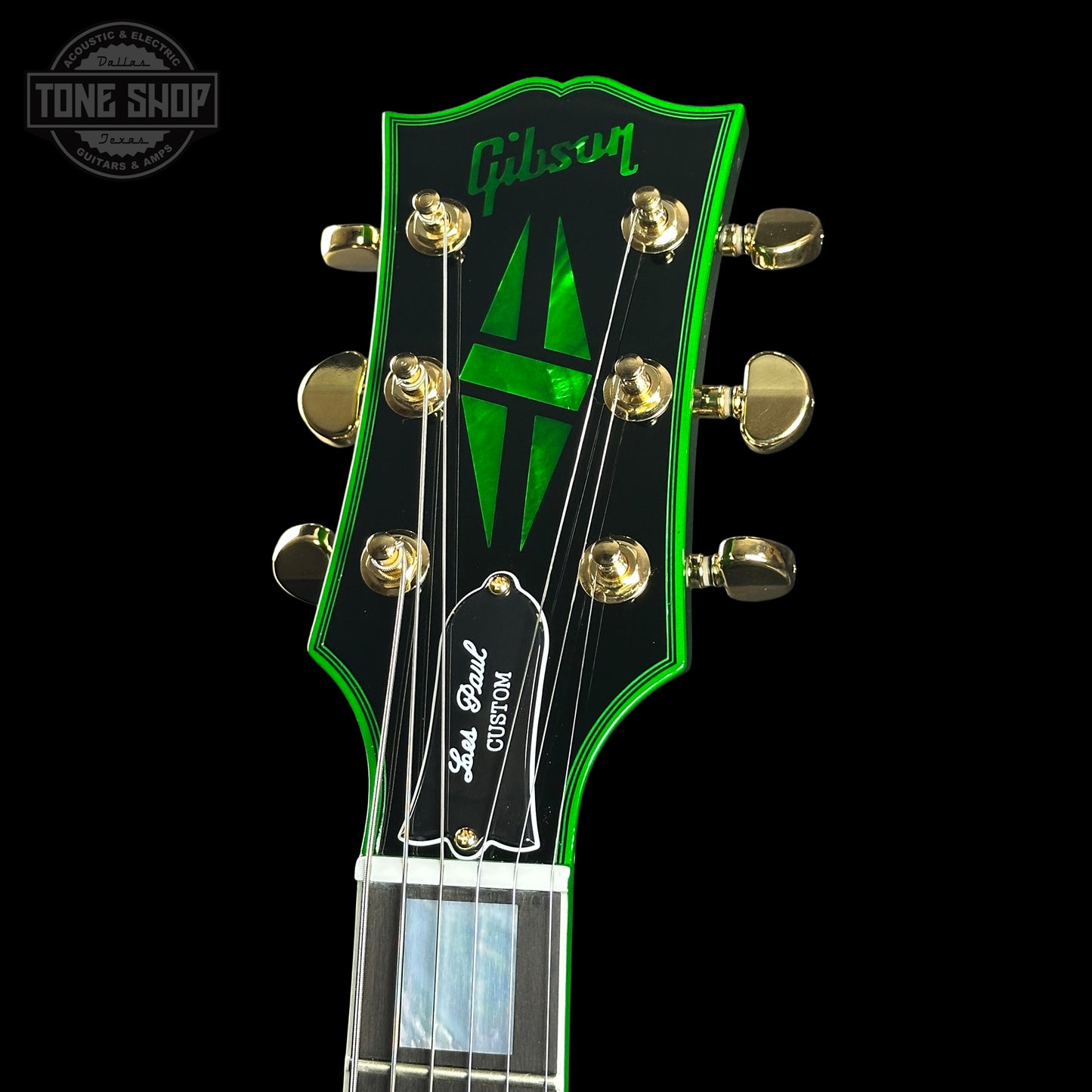 Gibson guitar headstock with green logo on a black background