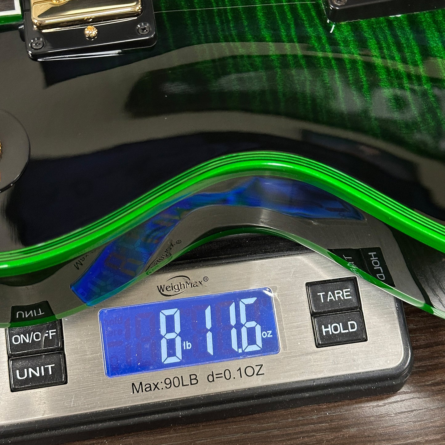 Digital scale displaying weight with green material on top