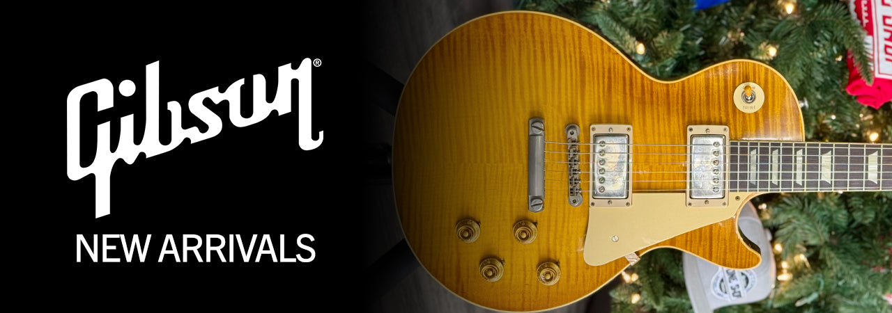 Photo of Gibon Guitar in front of Christmas Tree with "Gibson new arrivals" above.