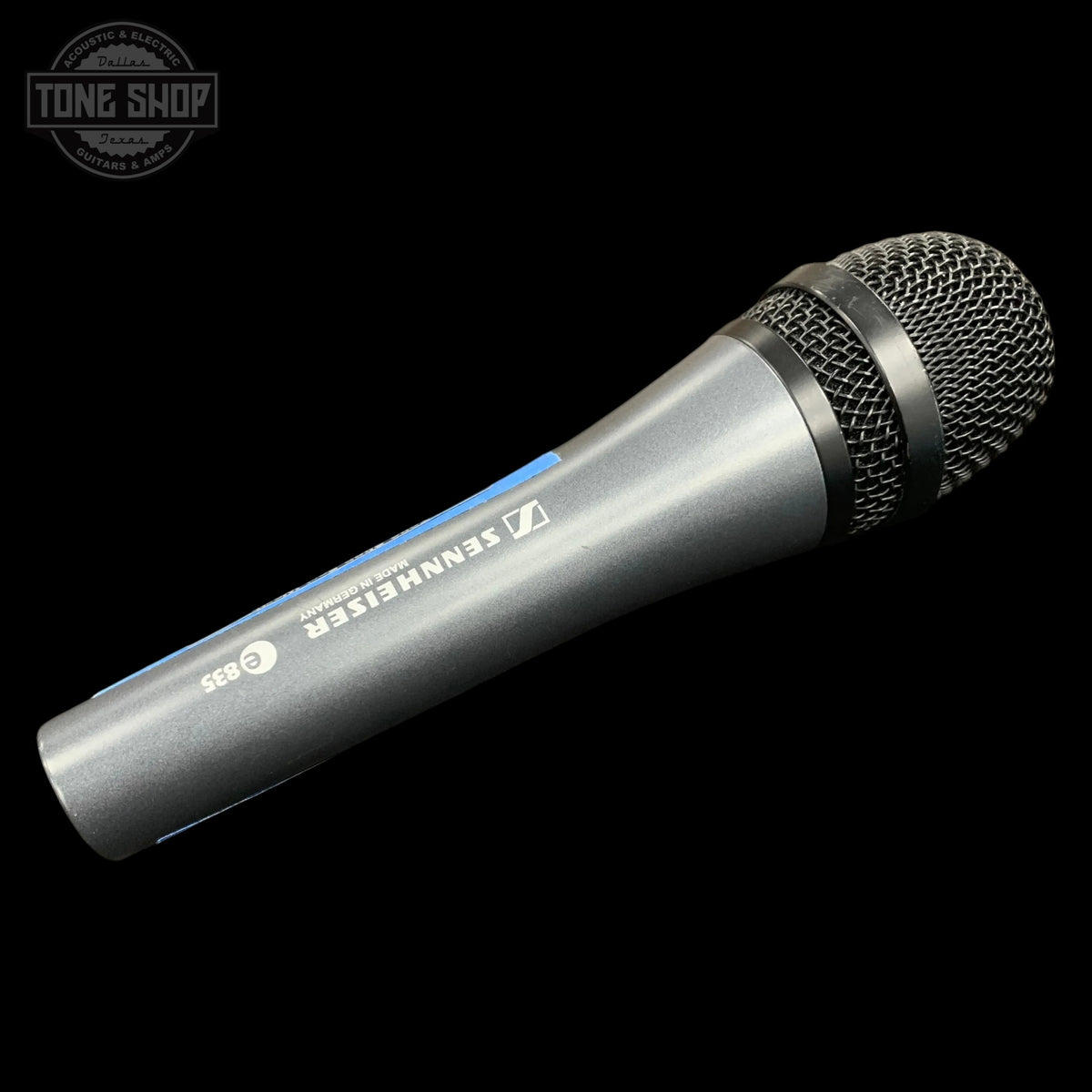 A Sennheiser G 93 handheld wireless microphone in silver and black with a blue accent stripe, shown diagonally on a black background with a Tone Shop watermark in the top-left corner.