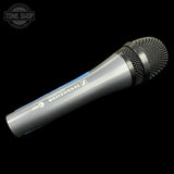 A Sennheiser G 93 handheld wireless microphone in silver and black with a blue accent stripe, shown diagonally on a black background with a Tone Shop watermark in the top-left corner.