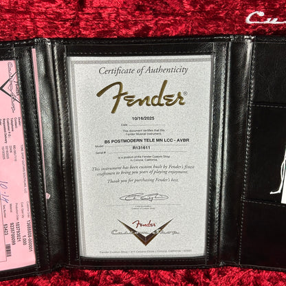 Fender certificate of authenticity in a black holder on a red textured surface