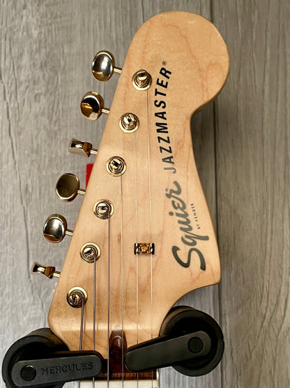 Headstock view of Used 2022 Squire 40th Anniversary Jazzmaster Gold Edition Olympic White