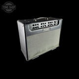 A black Marshall guitar amplifier with a silver grille and multiple control knobs on the front, shown against a solid black background with a Tone Shop watermark in the top-left corner.