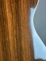 Close-up of a glossy brown wood-grain surface with a curved white edge and a reflective light area above it.