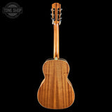 The back of a wooden acoustic guitar, showing the natural wood grain on the body and neck, photographed against a solid black background with a Tone Shop watermark in the top left corner.