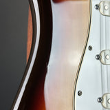 Close-up detail of an electric guitar body showing the sunburst finish, edge contour, and part of the white pickguard with metal screws.
