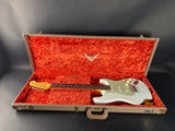 Electric guitar in an open case with a red interior on a dark background