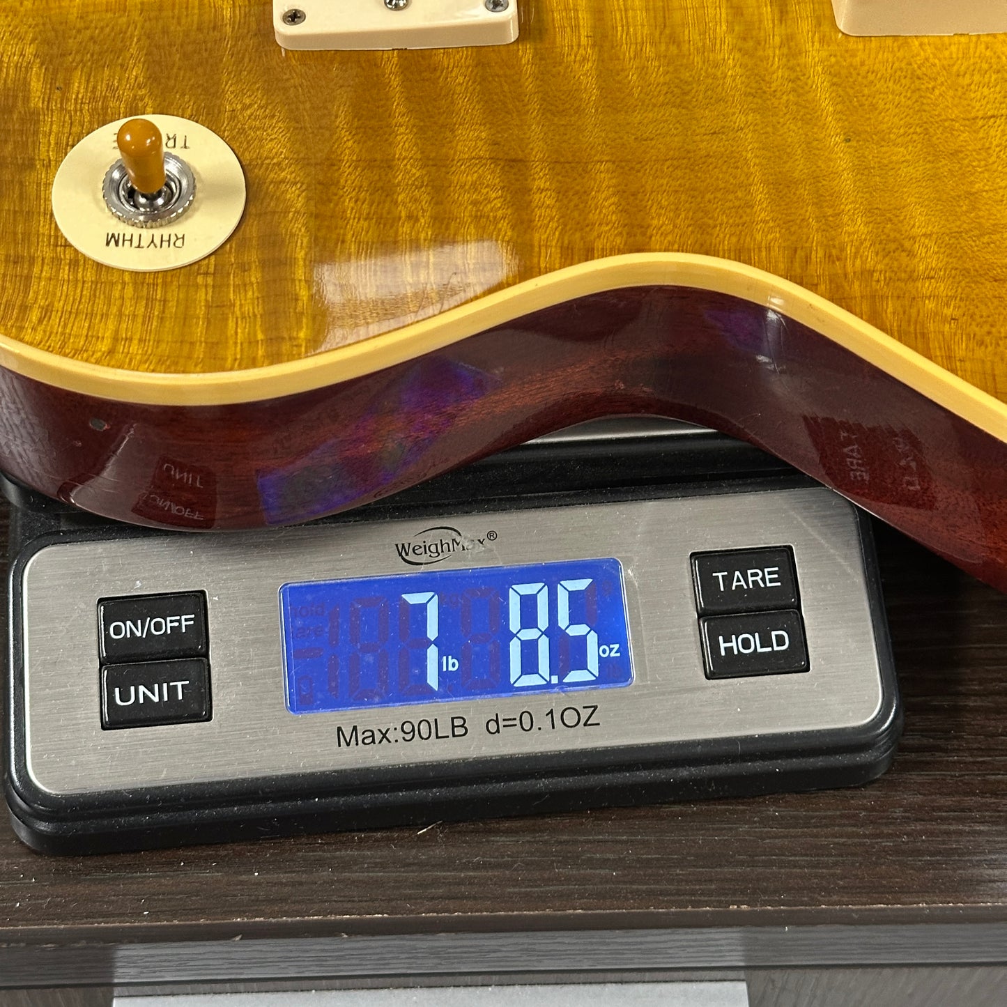 Guitar on a digital scale displaying weight