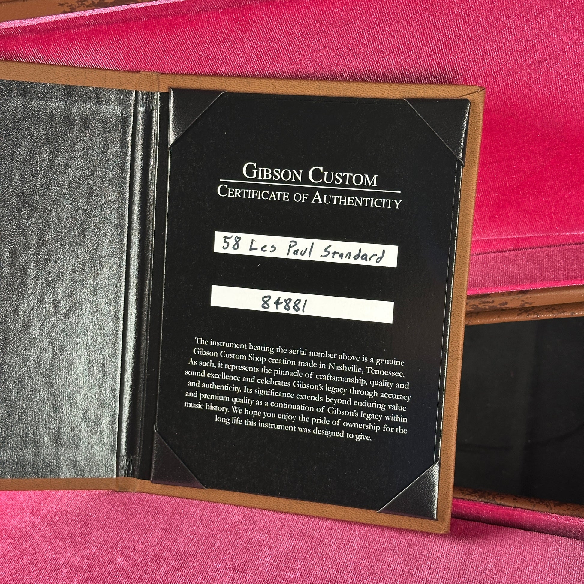 Gibson Custom Certificate of Authenticity inside a guitar case with pink interior.