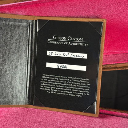 Gibson Custom Certificate of Authenticity inside a guitar case with pink interior.
