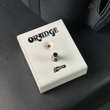 Orange guitar effects pedal on a dark surface
