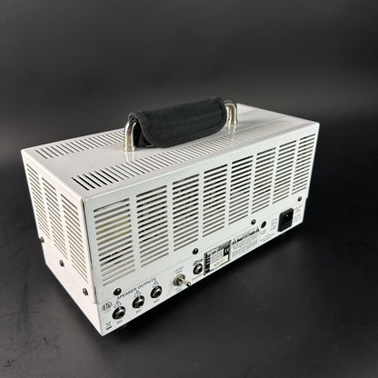 White electronic device with a black handle on a dark background