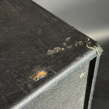 Close-up of a black leather-bound book with visible wear and tear.