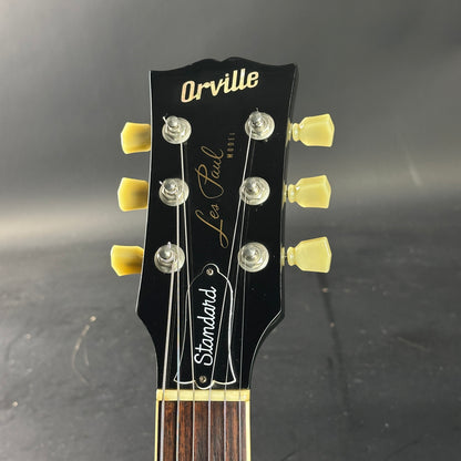 Guitar headstock with 'Orville' branding on a dark background