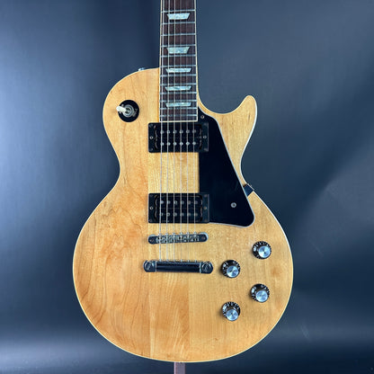 Electric guitar with a natural wood finish on a dark blue background
