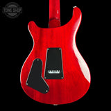 The rear view of a red electric guitar body with black pickguard and control plate, shown against a black background with a Tone Shop watermark in the top left corner.