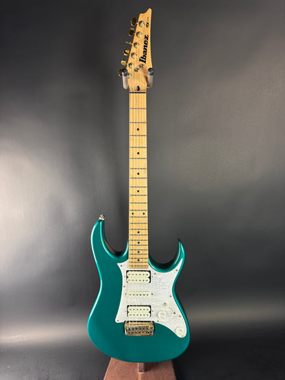 Teal electric guitar on a dark gray background