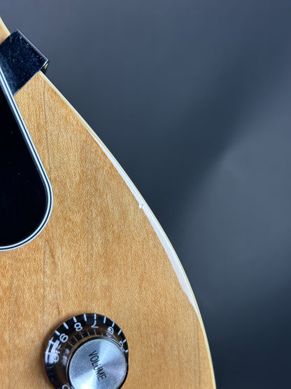 Close-up of a guitar's volume knob on a wooden surface with a dark background
