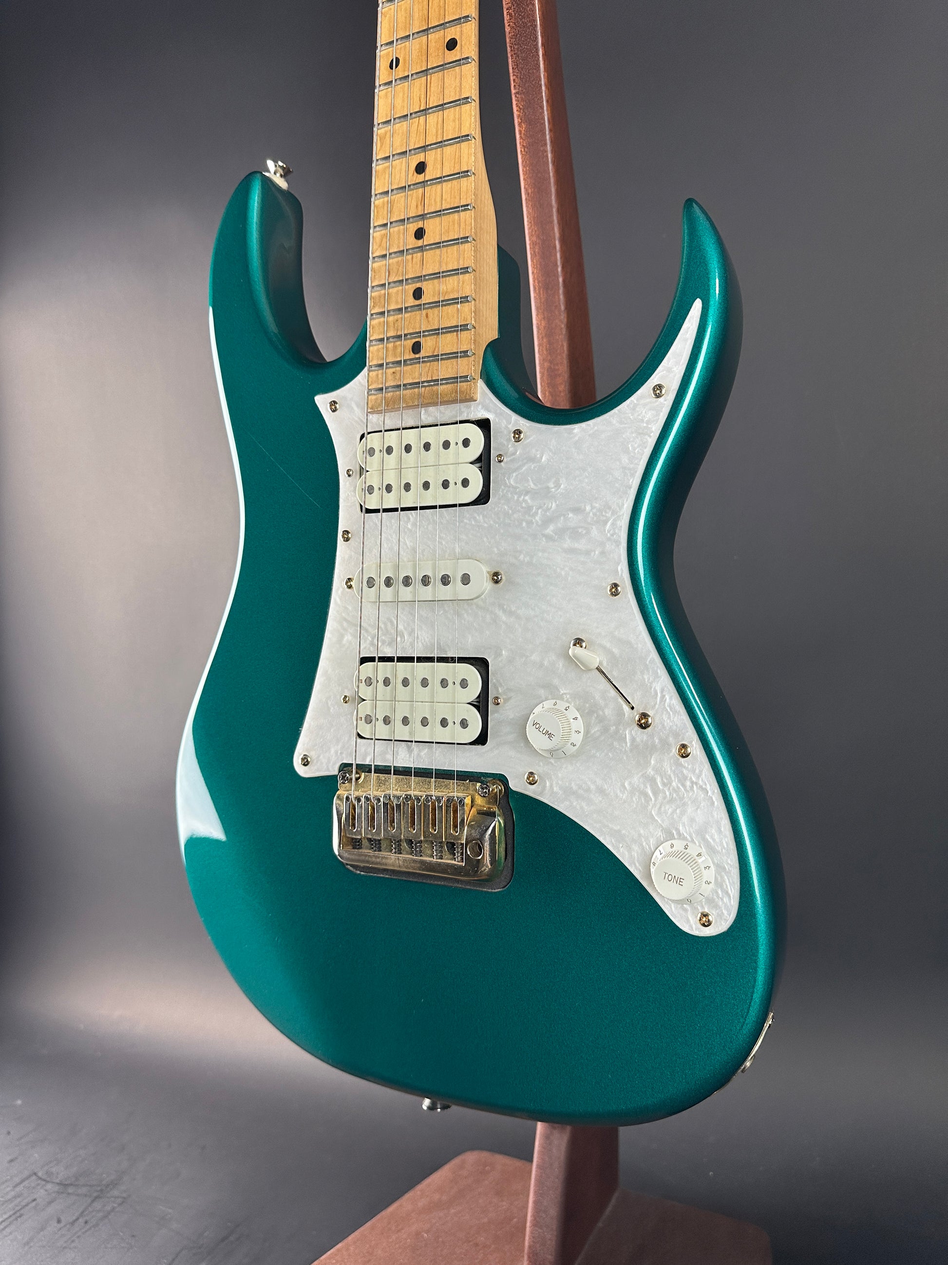 Teal electric guitar on a gray background