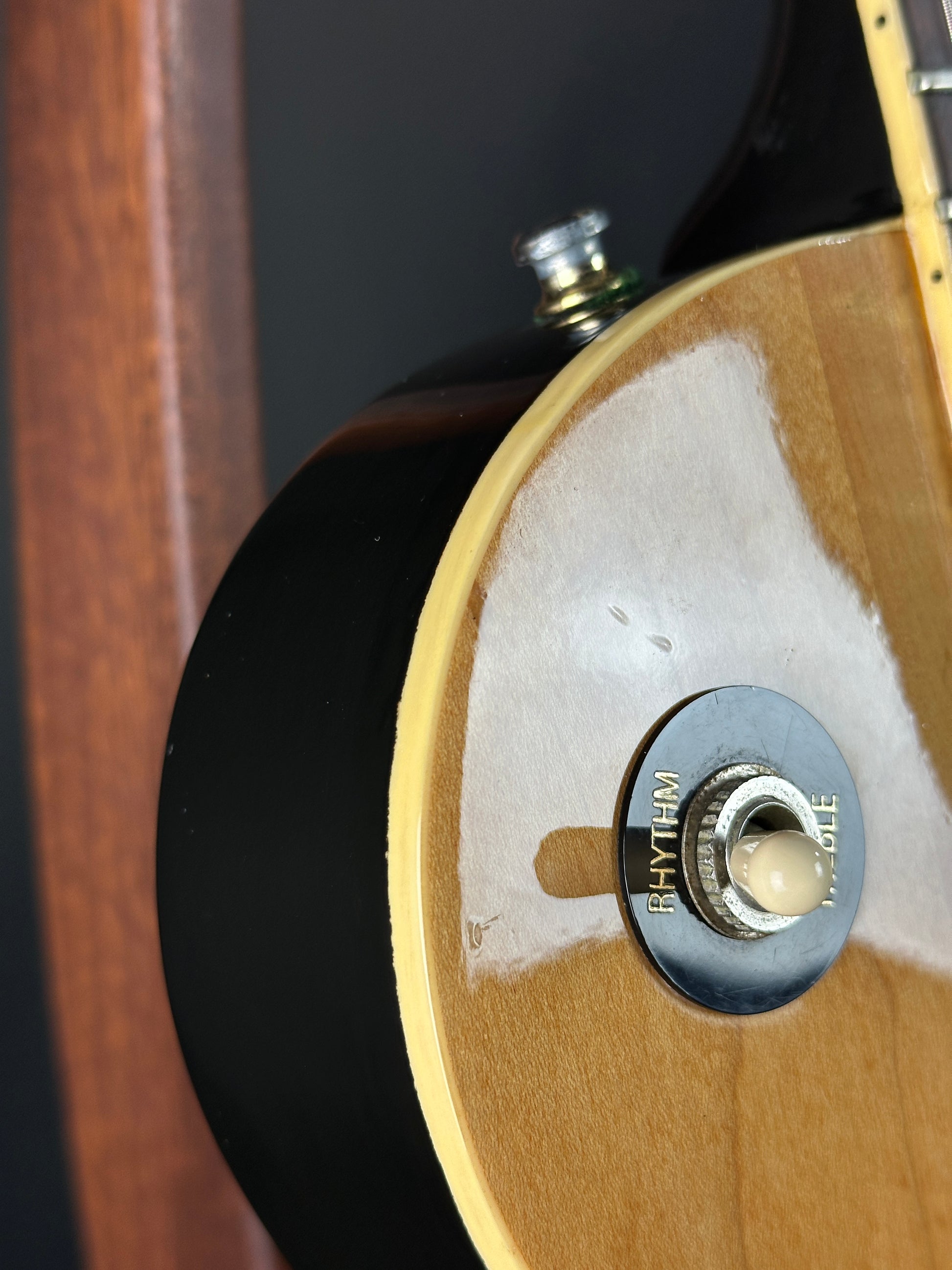 Close-up of a guitar's pickup selector switch with a wooden finish.