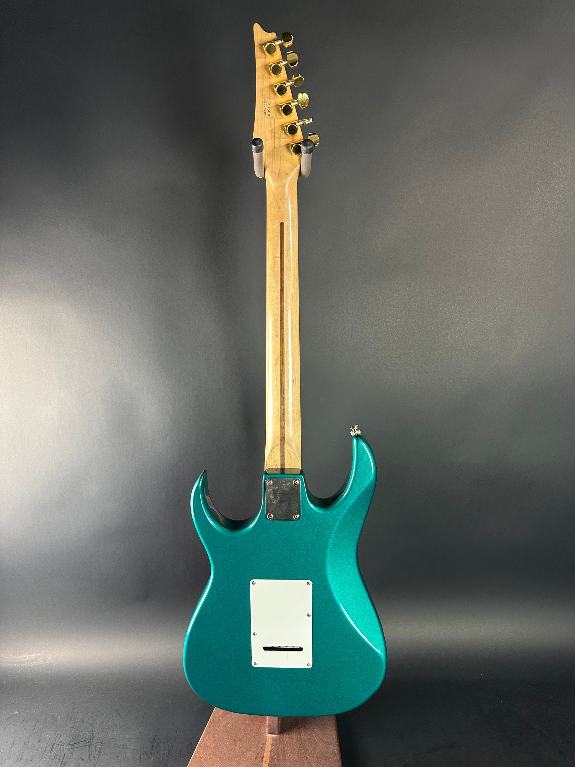 Teal electric guitar on a dark gray background