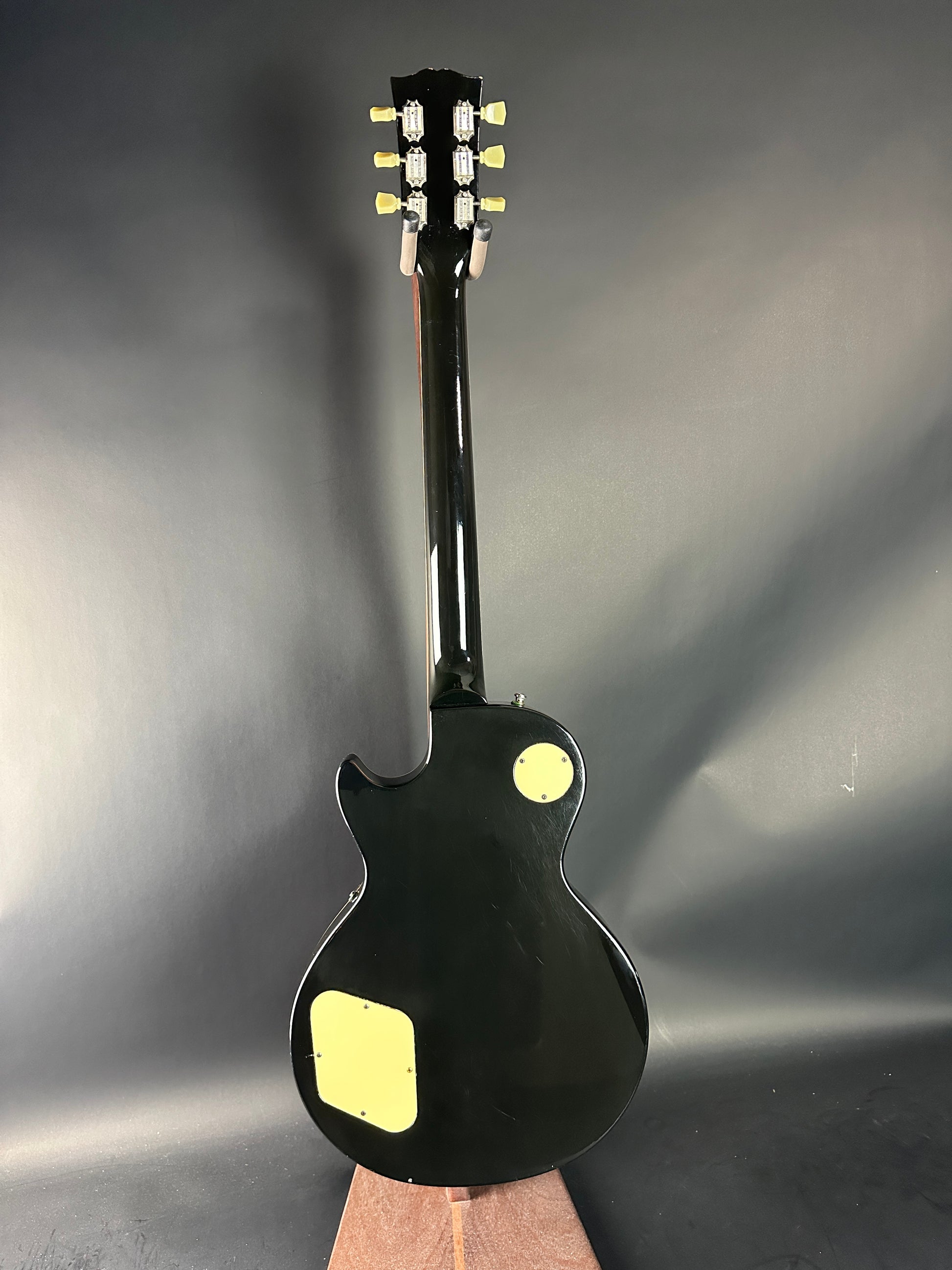 Black electric guitar on a gray background