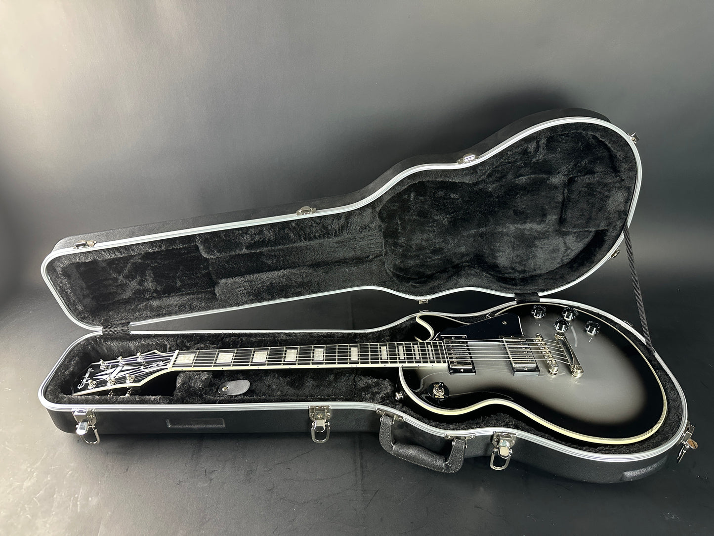 Guitar in an open case on a gray background