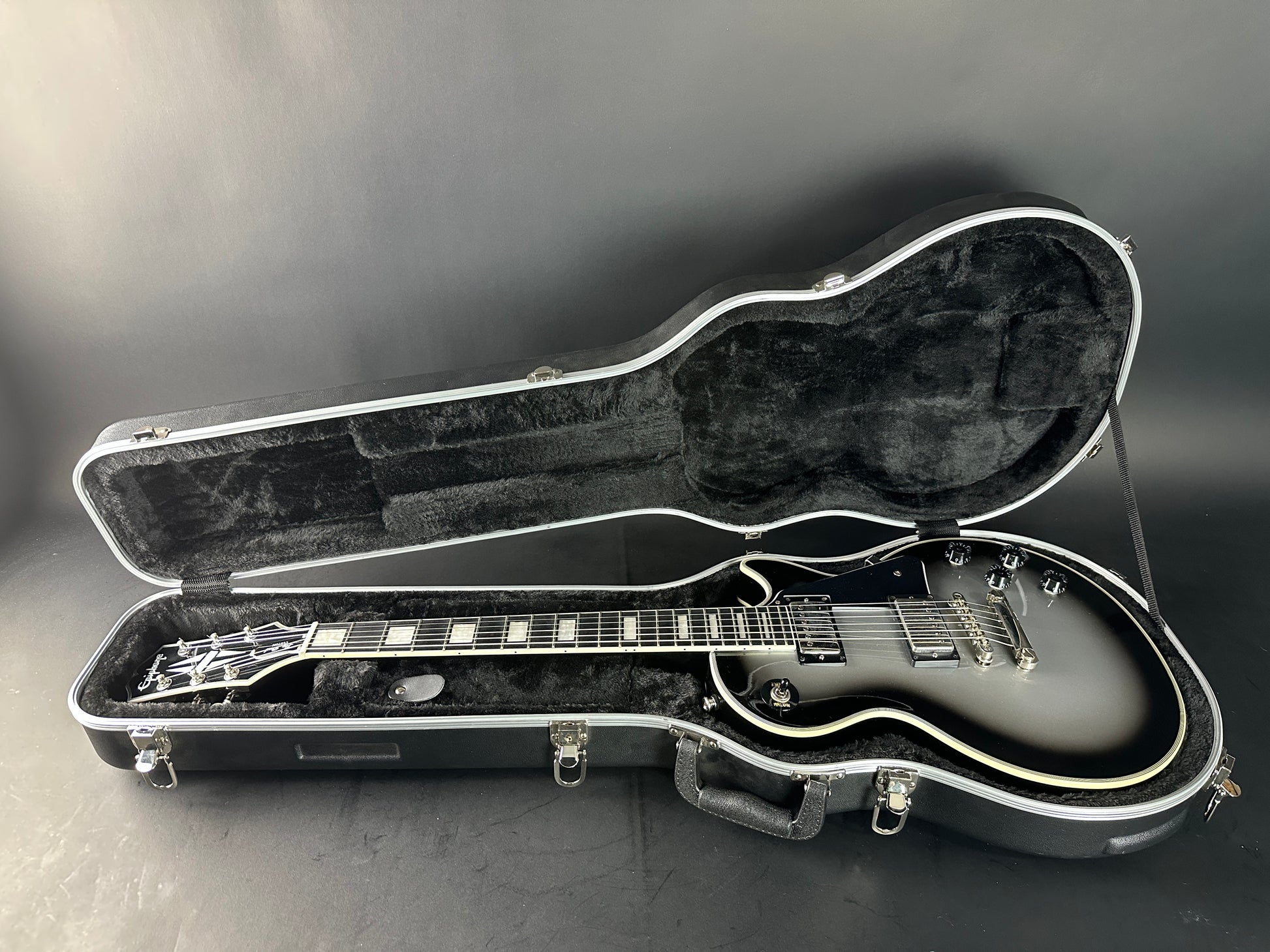 Guitar in an open case on a gray background