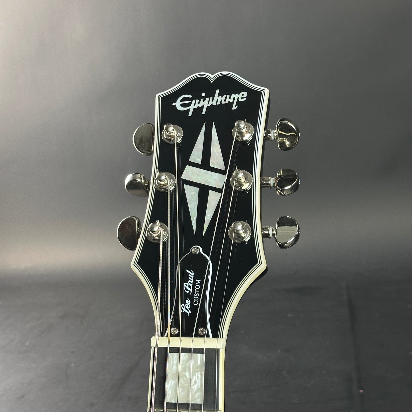 Epiphone Les Paul Custom guitar headstock on a gray background