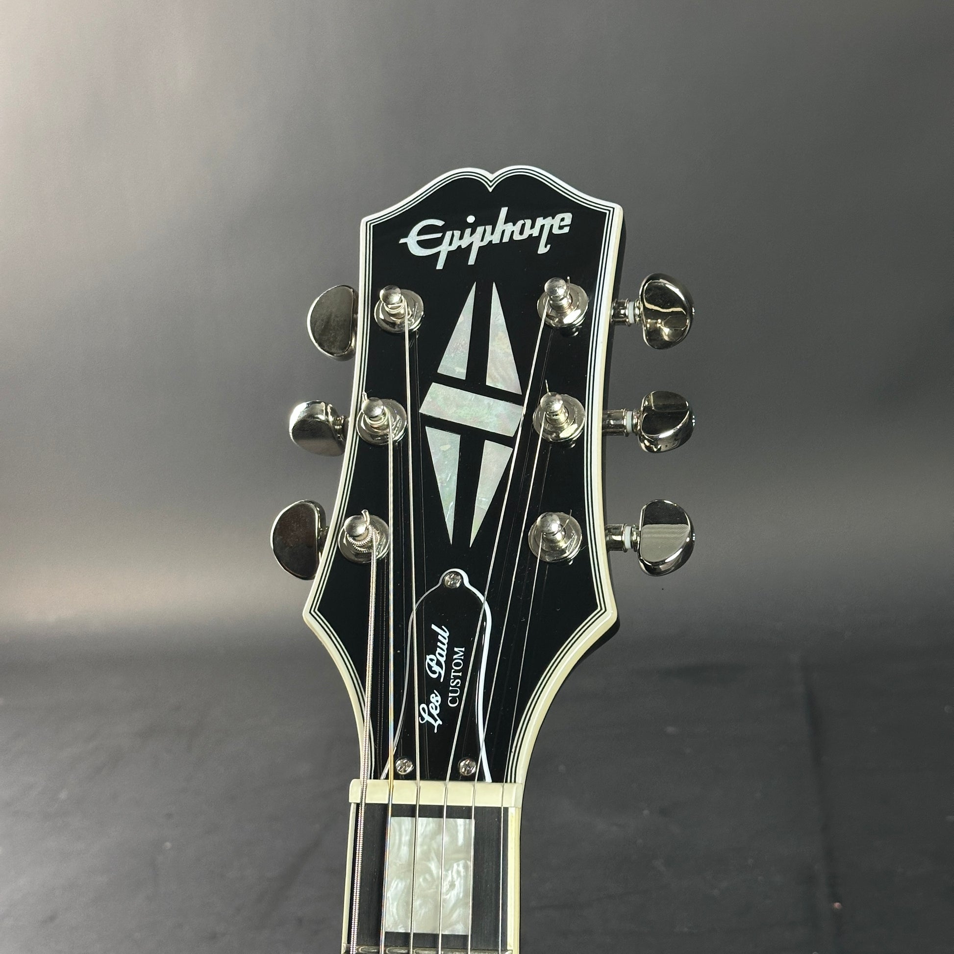 Epiphone Les Paul Custom guitar headstock on a gray background