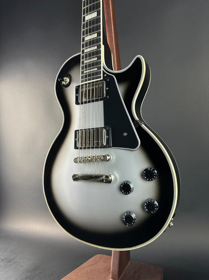 Close-up of a black and white electric guitar on a gray background