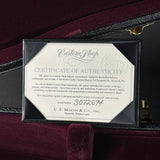 A framed Certificate of Authenticity for a custom Martin Custom Shop guitar, displayed inside an open black guitar case on a burgundy velvet interior. The certificate is from C.