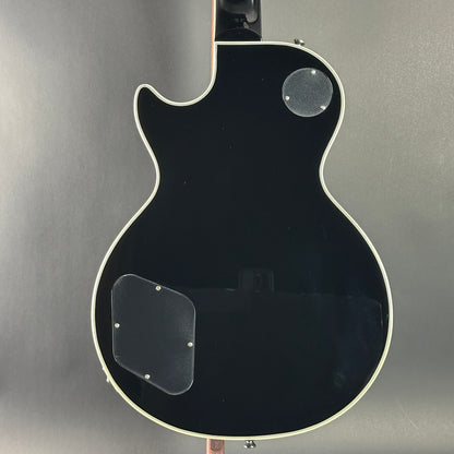 Black electric guitar on a gray background