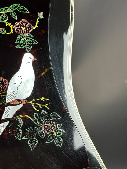 Decorative black surface with embroidered white bird and floral patterns