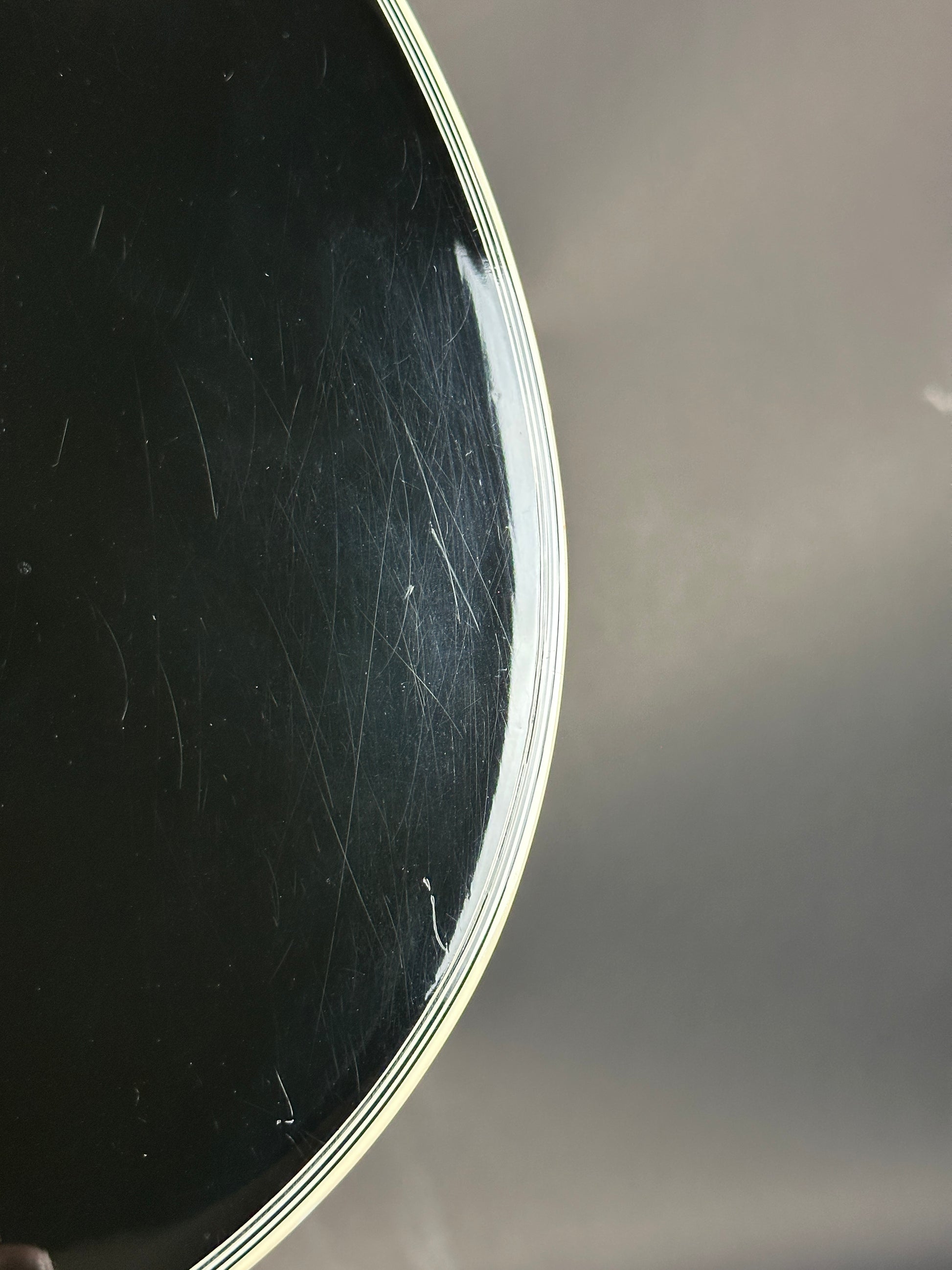 Scratched black surface with a white rim against a gray background