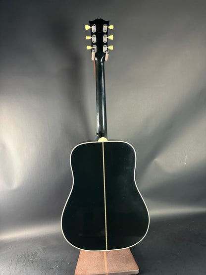 Black acoustic guitar on a reflective gray surface