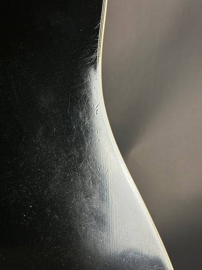 Close-up of a curved metal object with a reflective surface on a dark background