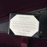 A framed Certificate of Authenticity for a Martin Guitar Custom Shop guitar, displayed inside an open black case with a burgundy velvet interior. The certificate is signed by C.