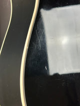 Close-up of a guitar's soundhole with visible scratches and reflections.