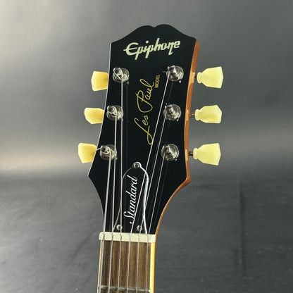 Guitar headstock with 'Epiphone' and 'Les Paul Standard' branding on a gray background