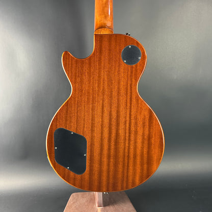 Back view of a wooden electric guitar on a gray background