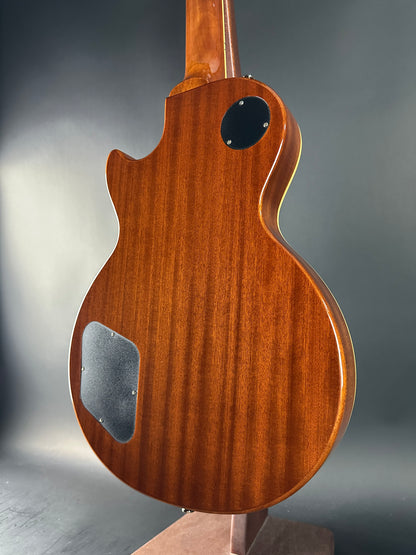 Close-up of a wooden guitar body with a dark gray background