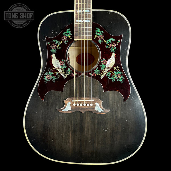 A vintage acoustic guitar with a dark wood body, featuring intricate inlay work of two white doves, green leaves, and red roses around the soundhole and bridge. The guitar is photographed against a solid black background with a Tone Shop watermark in the top left corner.