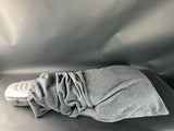 Gray garment draped over a white shoe on a gray surface