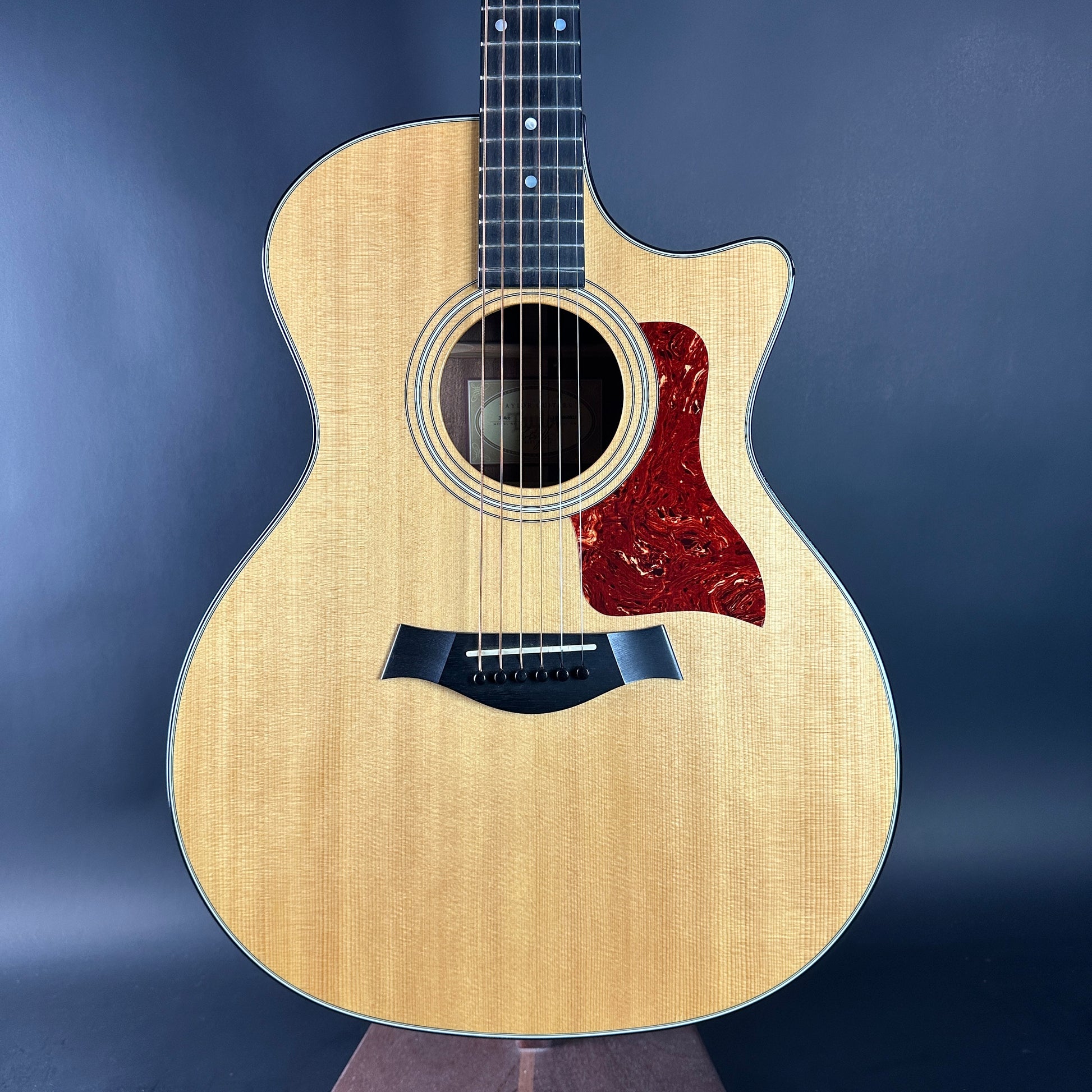 Acoustic guitar with a wooden finish on a dark blue background