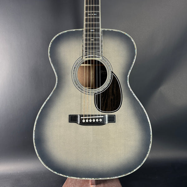 Acoustic guitar held against a dark background